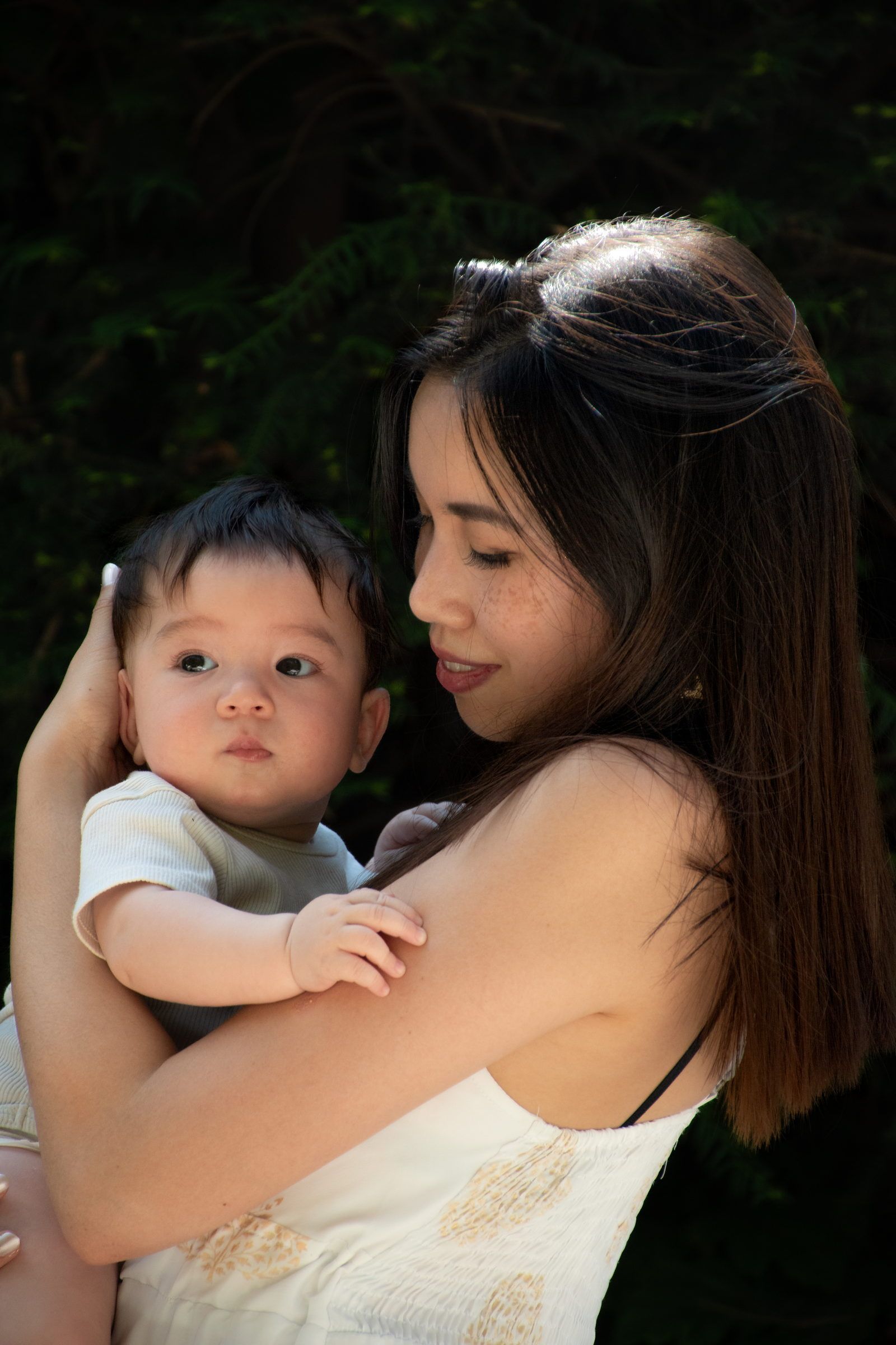 Une maman porte son bébé contre elle et le regarde