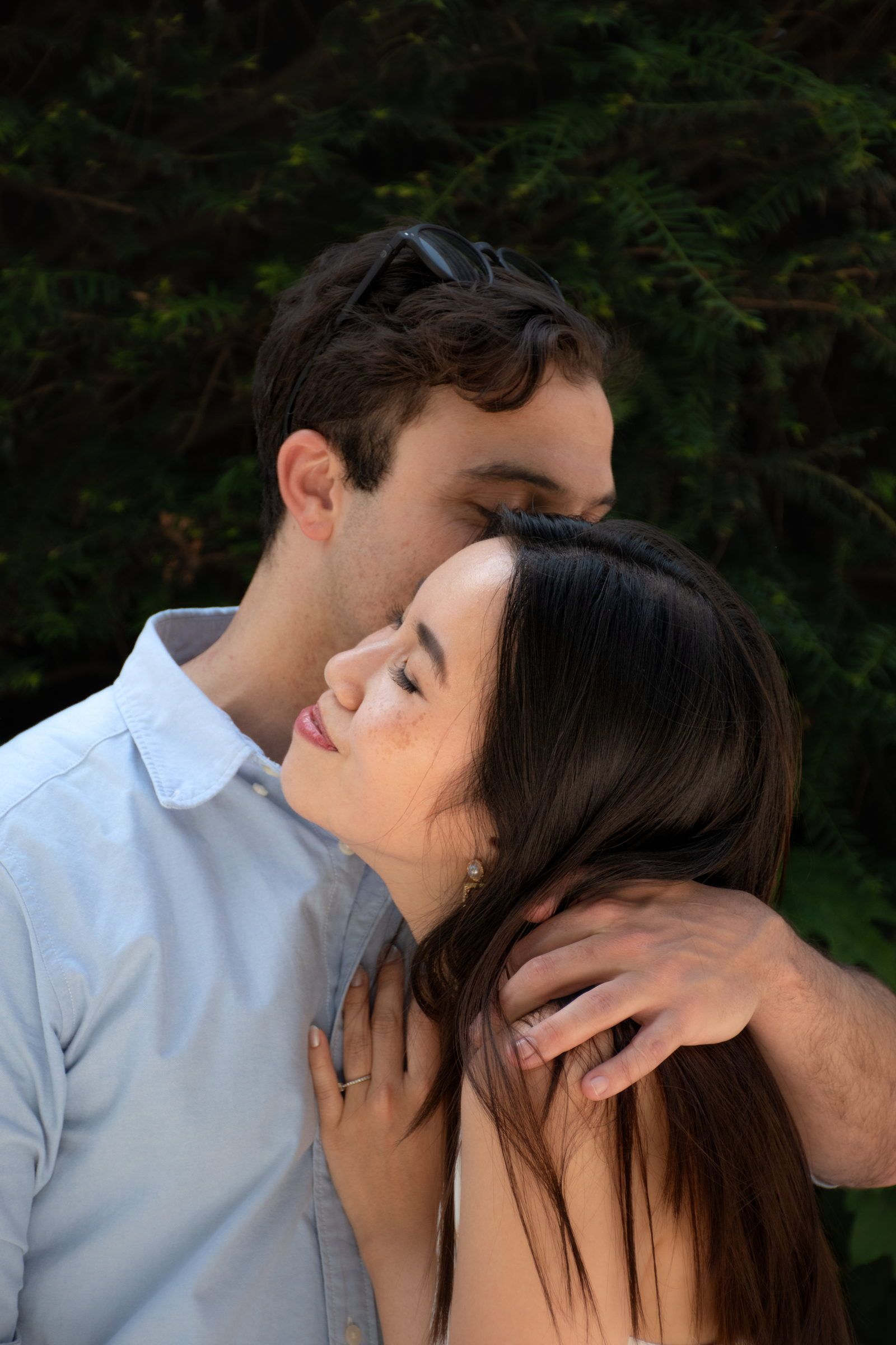 Un couple enlacé dans un jardin, les yeux fermés
